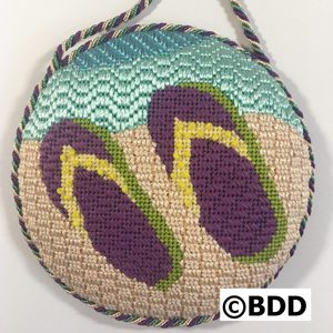 A round bag with flip flops on it.