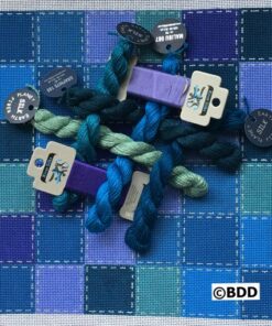 A group of yarn and buttons on top of a quilt.
