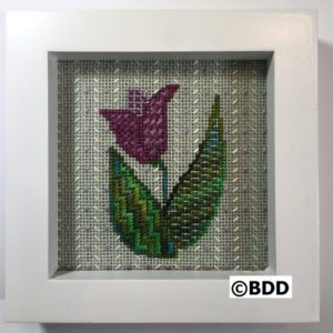 A white frame with a purple flower on it.