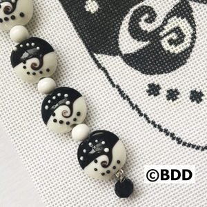 Black and white bead bracelet with a charm.