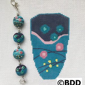 A blue bag with flowers and beads on it.