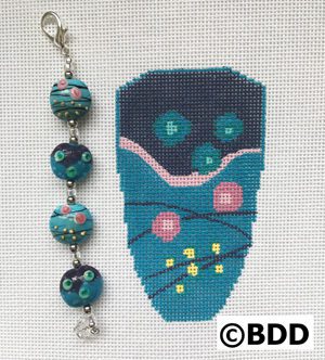 A blue bag with flowers and beads on it.