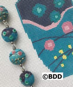 Turquoise lampwork beads next to teal stitching