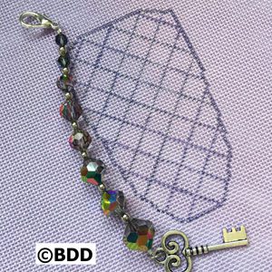 A key chain with a diamond pattern and beads.