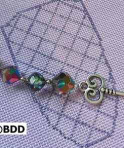 A key with a rainbow of beads on it.