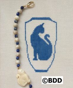 A cross stitch of a cat and bead.
