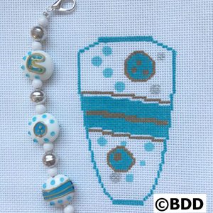 A blue and white cross stitch pattern with beads.