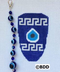 A blue and white cross stitch ornament with an evil eye bead.