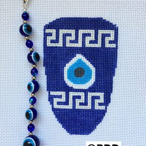 A blue and white cross stitch ornament with an evil eye bead.