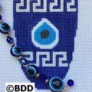 A blue and white cross stitch pattern with evil eye beads.