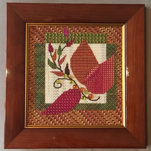 A picture frame with a cross stitch design on it.