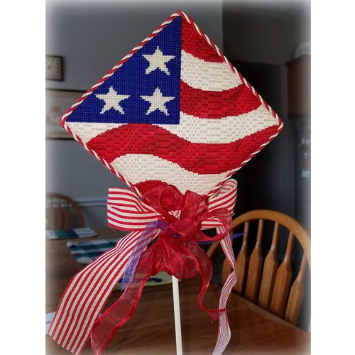 A patriotic kite sitting on top of a wooden table.