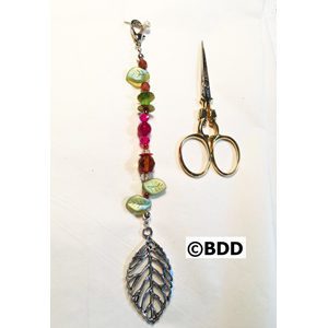 A pair of scissors and a leaf charm.