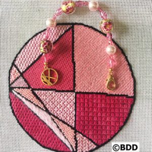 A pink cross stitch ornament with peace sign.