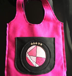 A pink bag with a black circle on it.