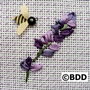 A purple flower and bee are embroidered on fabric.