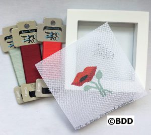 A picture frame with some fabric and a card