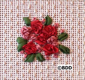 Cluster of ribbon roses embroidered on canvas