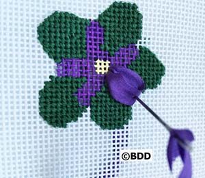 A cross stitch flower with purple petals and green leaves.