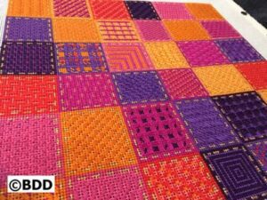 A colorful rug with many different colors of fabric.