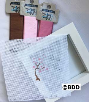 A white frame with some pink and brown ribbons