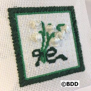 A cross stitch picture of flowers on the front.