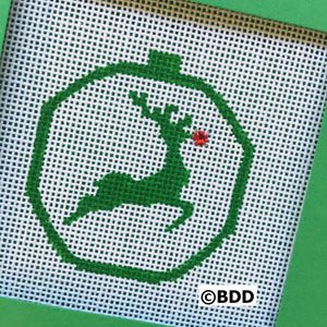 A green cross stitch picture of a reindeer.