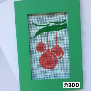 A green frame with red cherries hanging on it.