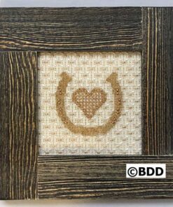 A picture frame with a cross stitch heart in the middle.