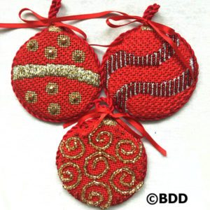 Three red ornaments with gold and silver designs.