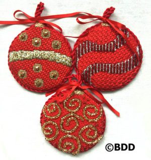 Three red ornaments with gold and silver designs.