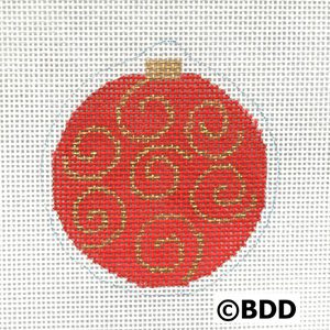 A red ornament with gold swirls on it.