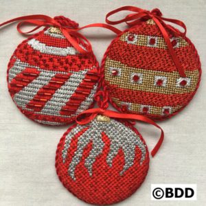 Three red and silver ornaments with a ribbon.