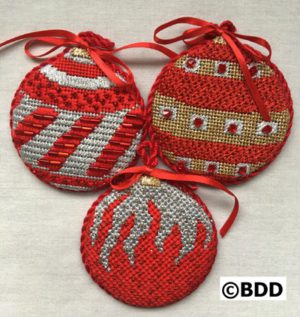 Three red and silver ornaments with a ribbon.