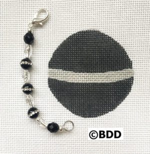 A black and white bead with a silver chain