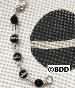 A black and white cross stitch pattern with beads.