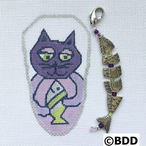 A cat with a candle in it's mouth and a key chain.