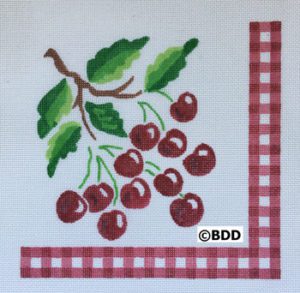 A red checkered napkin with cherries on it.