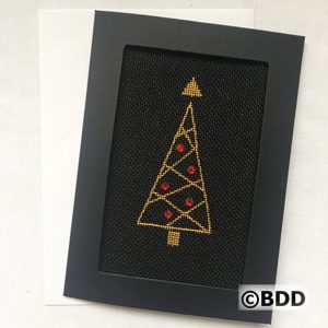 A black framed picture with a gold and red tree.