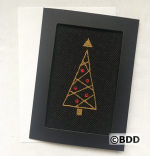 A black framed picture with a gold and red tree.