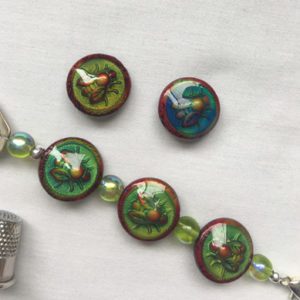 A bracelet with four buttons and a key chain.