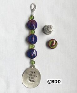 A key chain with beads and a silver spoon.