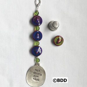 A key chain with beads and a silver spoon.