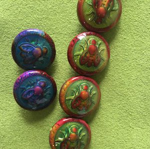 A group of six buttons with different designs on them.