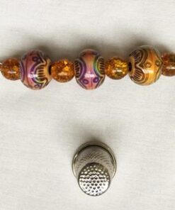 A key chain with beads and a thimble