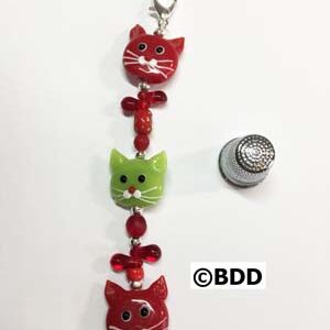 A red and green cat keychain hanging on the wall.