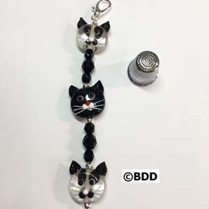 A black and white cat bracelet with a silver charm.