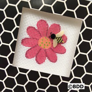 A bee on the flower of a cross stitch pattern.