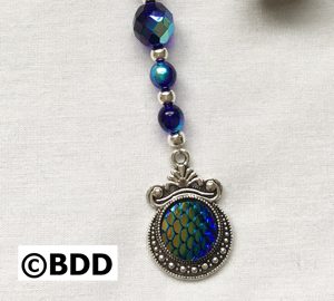 A blue and green bead with a silver pendant.