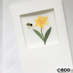 A yellow flower with green leaves and a bee on it.